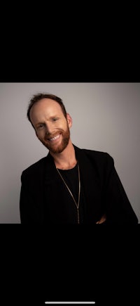 a man with a beard smiling for the camera